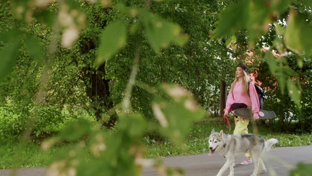 The girl is walking with the dog