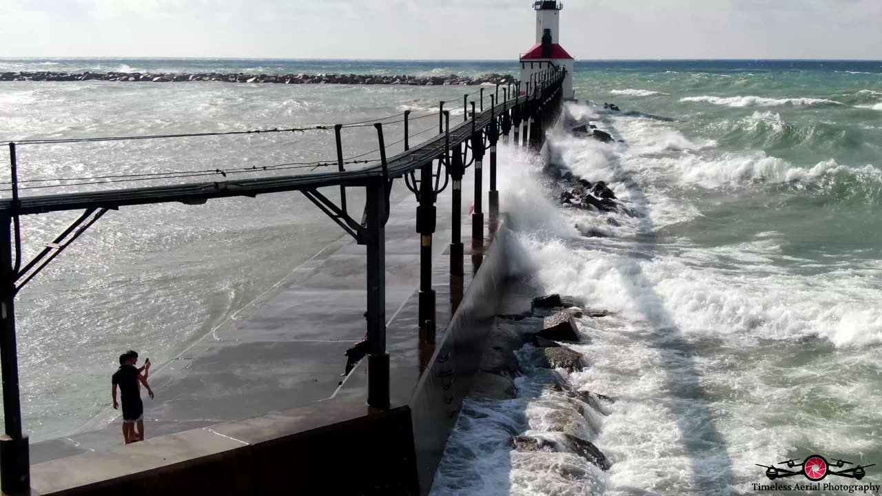 People Almost Swept Off Pier As Massive Waves Slam Into The Lighthouse Pier 4K Drone Footage