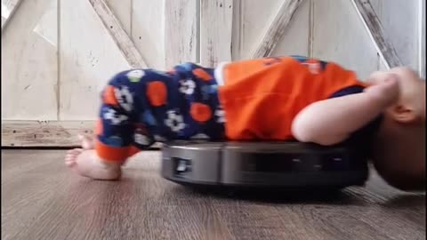 Son Relaxes On Robot Vacuum