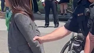 Is AOC pretending to be handcuffed as she’s escorted from a protest outside the Supreme Court?