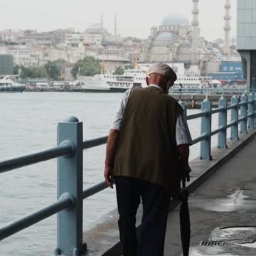 Old man walking alone at river bank
