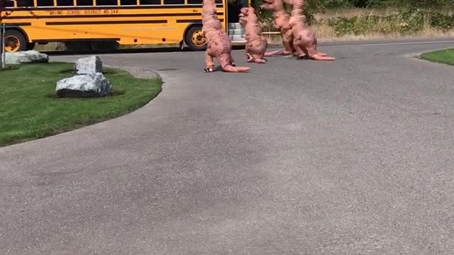 Family Of Dinosaurs Is Waiting For A Girl To Get Off The School Bus