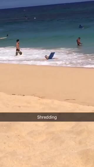Guy with blue boogie board gets knocked down by wave