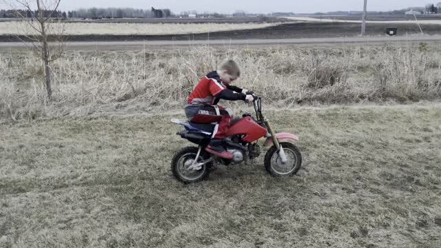 Kid trying to kickstart start dirt bike