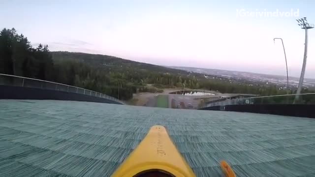 Shirtless guy in yellow canoe down hill