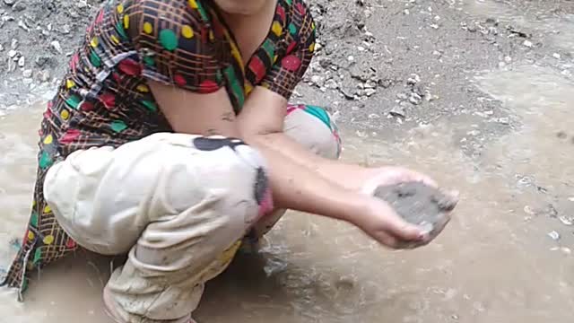 In heavy Rain cute little kid playing mud