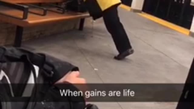 Man does semi-pushups off of a seat in a subway station