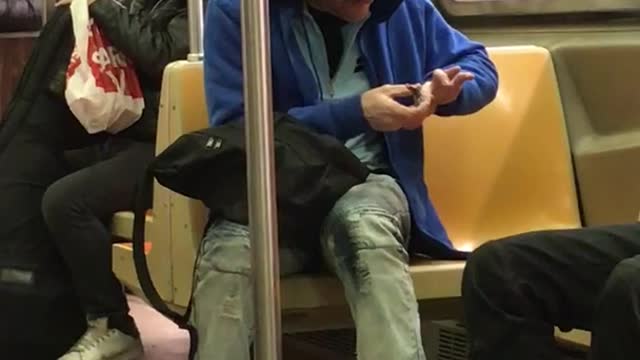 Blue hoodie guy clips nails on subway