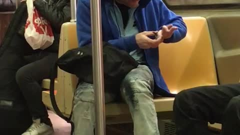 Blue hoodie guy clips nails on subway