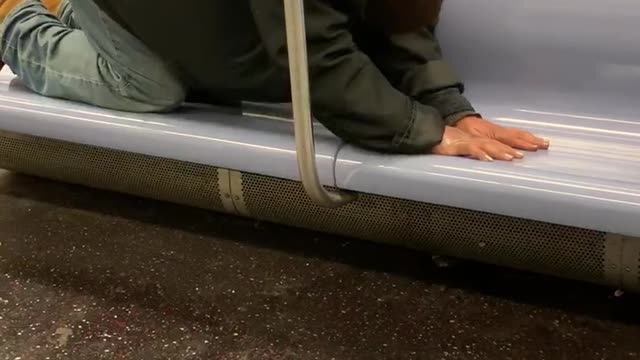 Man face down on subway seat exercising