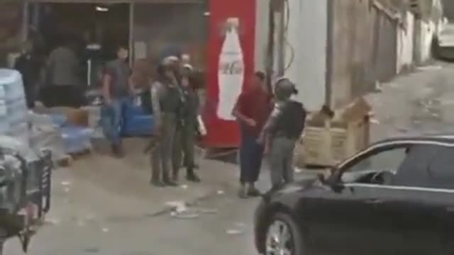 Israeli forces detain a Palestinian child while raiding Al-Ram