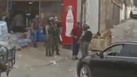 Israeli forces detain a Palestinian child while raiding Al-Ram