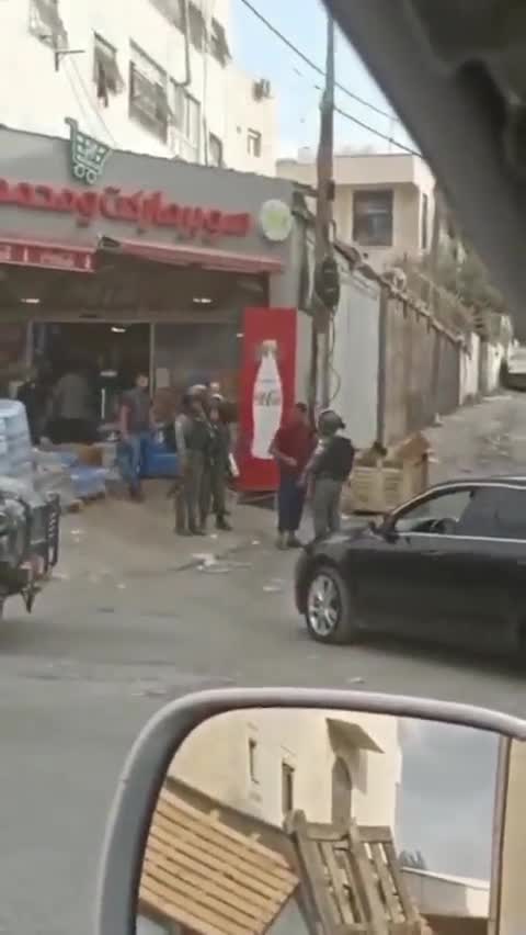 Israeli forces detain a Palestinian child while raiding Al-Ram