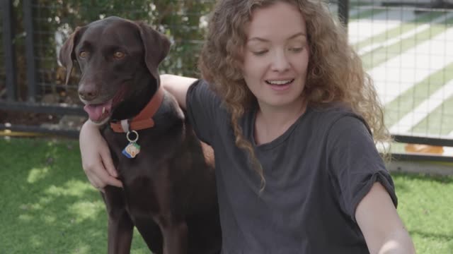 A Woman Petting Her Dogs Outdoors