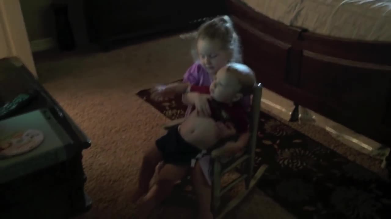 Little Girl Preciously Holds Baby Brother To Watch TV