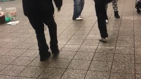 Four men gather to dance in circle at subway station