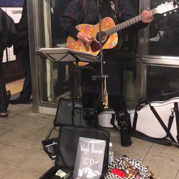 Man with basket on head plays weird guitar
