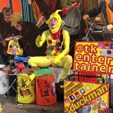 Chicken outfit man playing drums