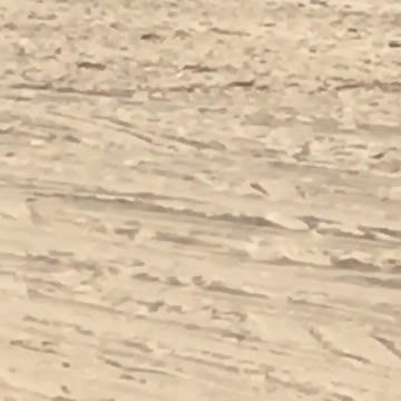 Man in all grey sweat suit training on beach