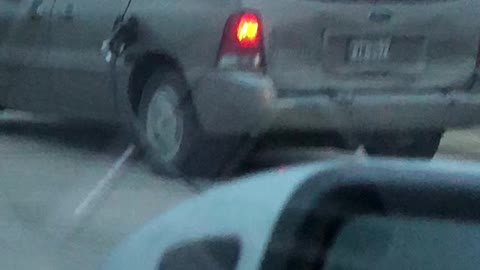 Car Drives Along With Gas Pump Handle Hanging From Car