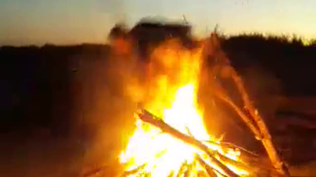 Adventurous Guy Jumps Over Fire With A Large Branch