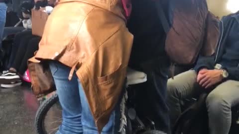Man and woman hugging next to bike on subway train
