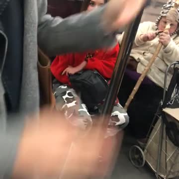 Woman in white cutting her cane on train
