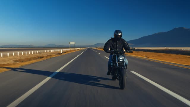 Man traveling by motorcycle on an empty road