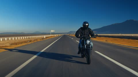 Man traveling by motorcycle on an empty road