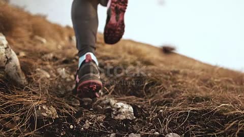 Feet of a female runner pushing gravel and dirt into the air