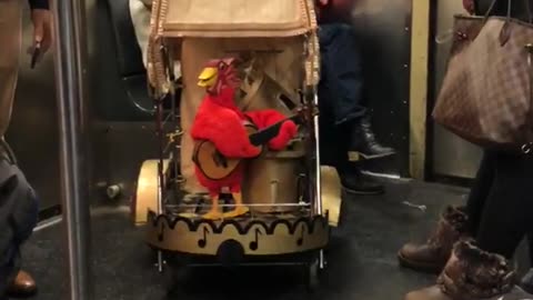 Red toy bird on stroller in subway