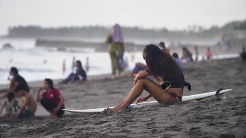 Woman Sitting with Surfboard On Echo Beach