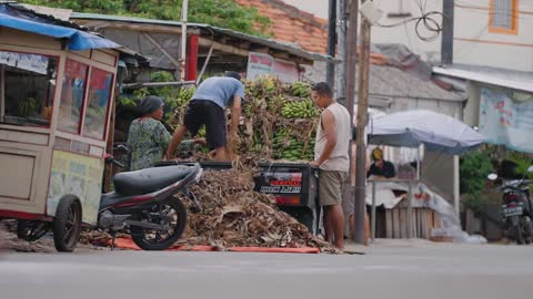 Low Angle Shot of Workers Unloading Bananas from a Van