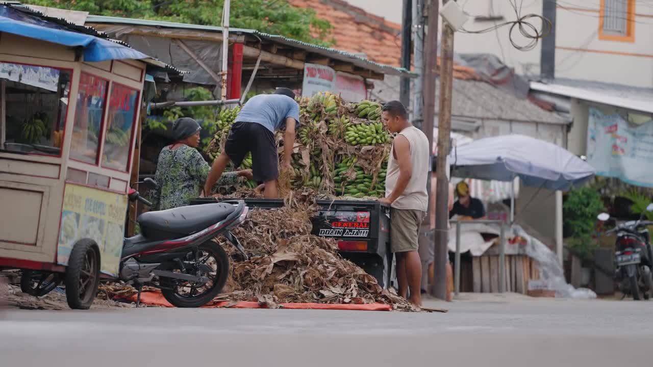 Low Angle Shot of Workers Unloading Bananas from a Van
