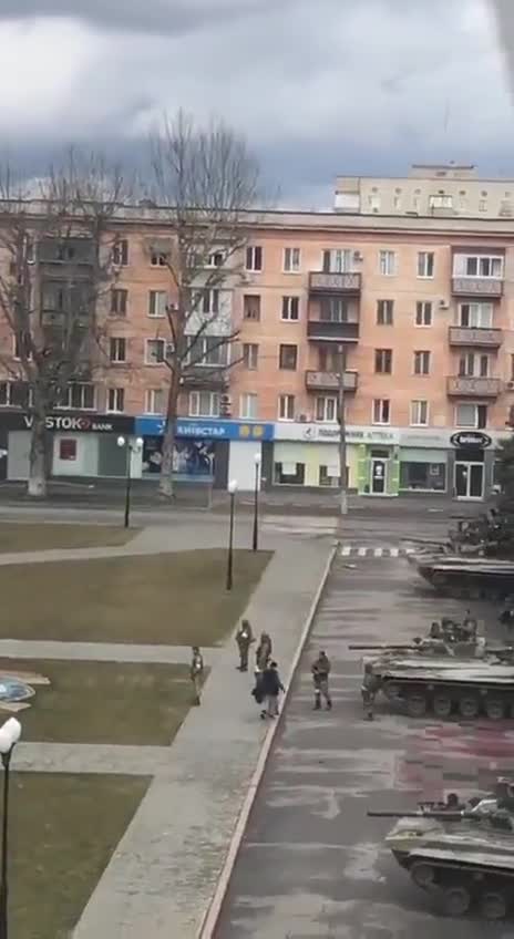 Ukrainian raises the Ukrainian flag in front of the Russian army in defiance of them
