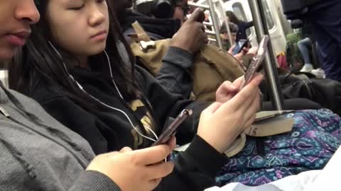 Girl eats asada fries on subway train, girl next to her texts on her phone