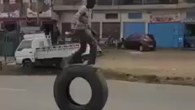 boy playing with big truck tire