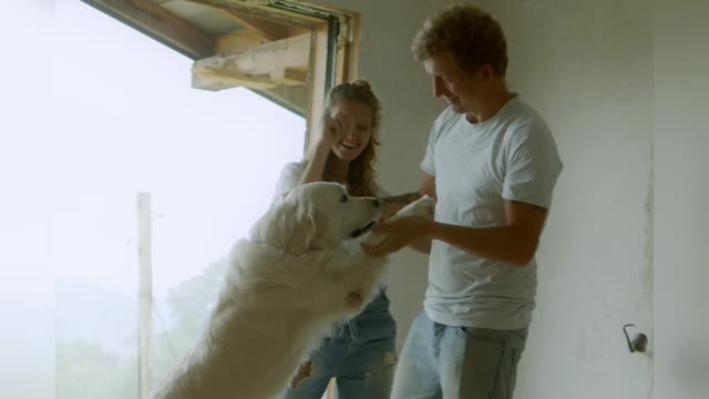 A happy family dancing with there white Dog