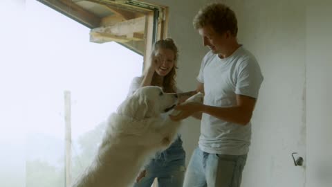 A happy family dancing with there white Dog