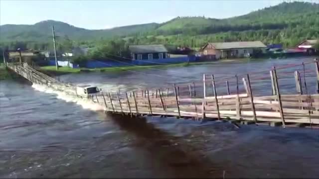 Suspension bridge collapses in flooded Russian river