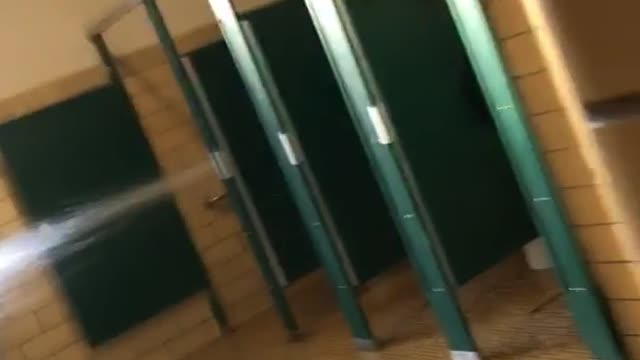 Guy walks into restroom toilet water spray out of stall