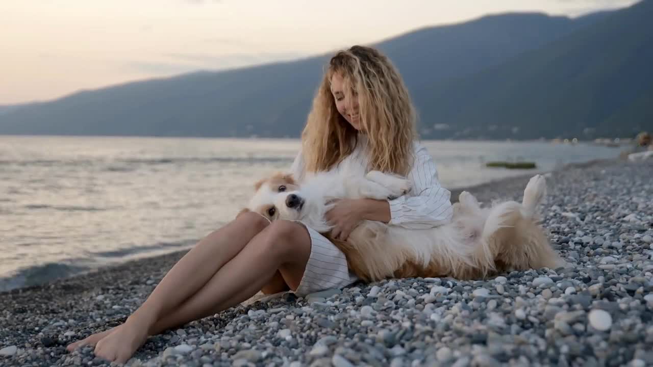 Best friends tender moment. Young curly girl holding her border collie dog like a baby