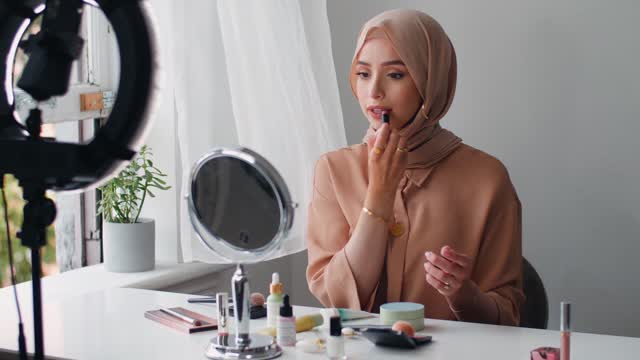 woman putting on lipstick