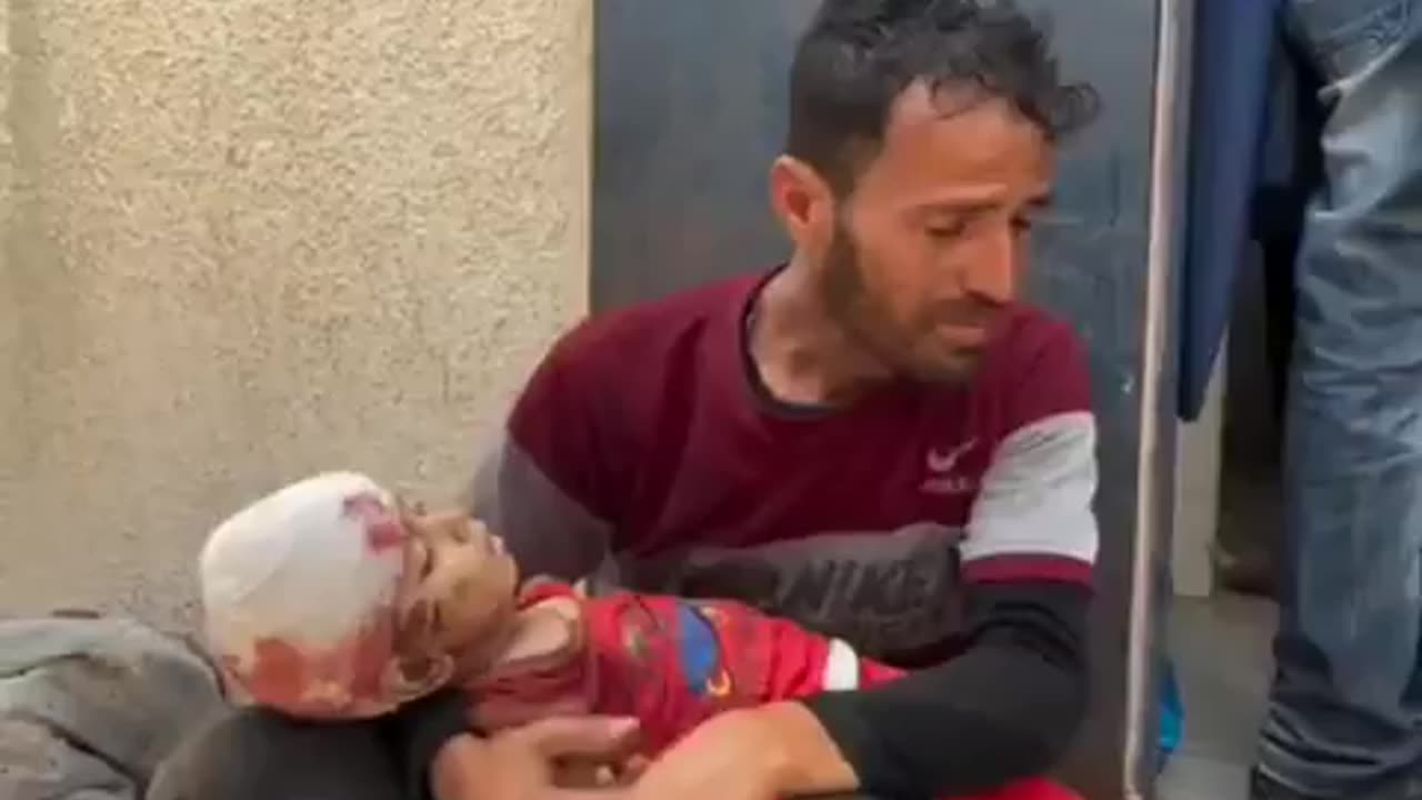 Traumatized father carries his child who was murdered in Israel's latest massacre