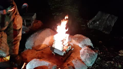 Making campfire at night riverside wildcamping