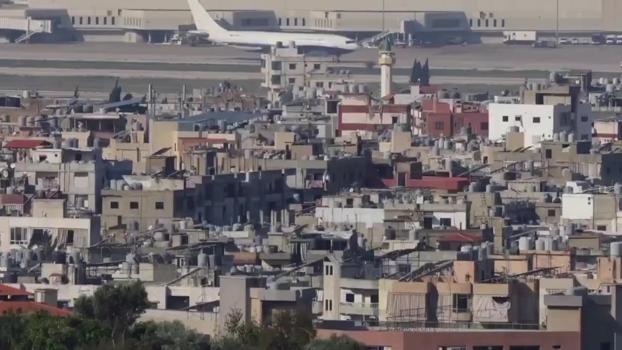 Strike hits near Beirut airport as a plane is seen moving on the runway.