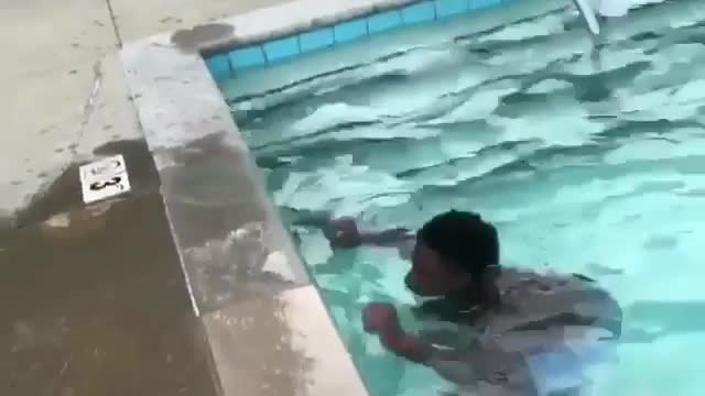 A man squatting in a swimming pool suddenly jumped up