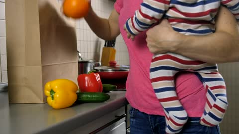 Mom with her baby in her hands starts cooking