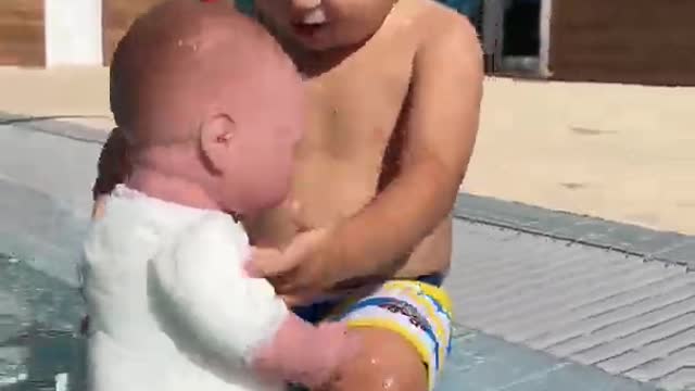 Baby David is playing in the pool with doll.