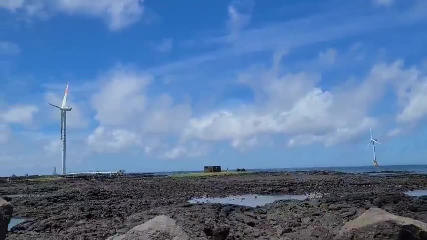 Wind turbines seen through coastal roads.